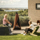 Tipi vedeldad eldstad utanför ett hus